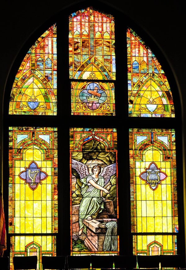 A vibrant stained glass window depicting a religious scene.